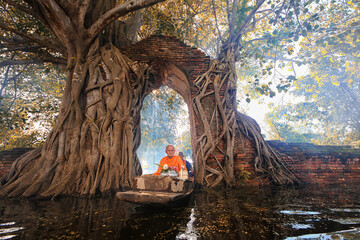 Monk transport by boat pass ancient temple during flood in Ayutthaya Historical Park, Thai Buddhist Monk Rowing Boat pass ancient temple underwater from flooded , Unseen Monk Alms-round receive food