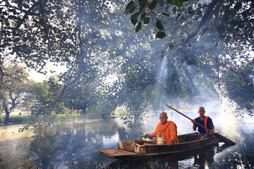 Monk transport by boat pass ancient temple during flood in Ayutthaya Historical Park, Thai Buddhist...