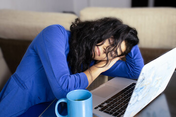 young female executive dressed in blue asleep at home during telework time due to exhaustion from blue Monday.
