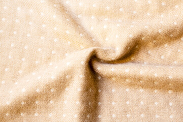 ベージュの布素材の背景　白いドット（水玉）柄とシワ
