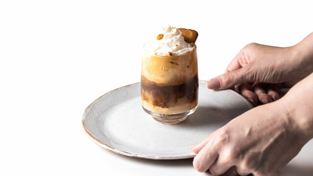 Hand holding try with Cookies layered coffee  decorated with whipped cream and cokkies .Bannr coy space