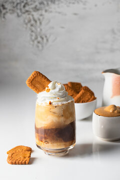 Biscoff coffee in the glass with ingredients on the white table.