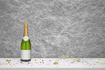Bottle of Champagne  & party decorations on a white table cloth