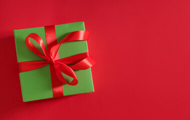 gift box green on red background with red bow with place for text	
