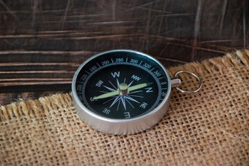 Compass on burlap. Geographical background close-up. Tourism, geography, path, direction