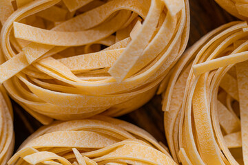 Homemade fettuccine pasta folded in the shape of a nest. Home cooking with ingredients for homemade...