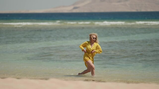 joyful woman is jumping on seashore, clumsy and funny, joke and comedy moments