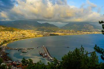 Obraz premium view of Alanya and the port illuminated by the setting sun with colorful clouds in autumn 