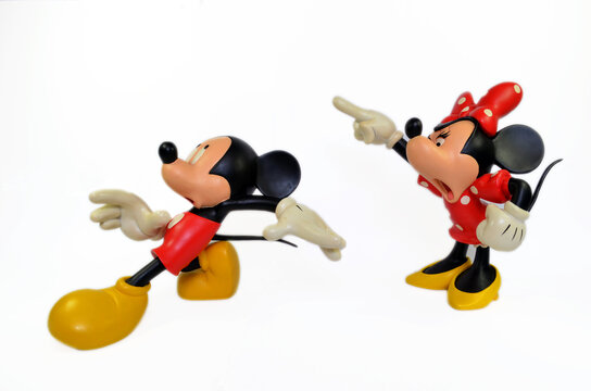 Mickey mouse is running away from an angry Minnie Mouse with a white isolated background