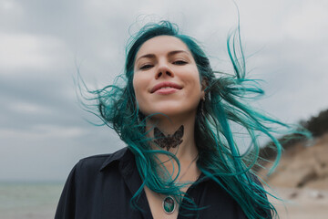 portrait of a beautiful woman with blue hair that flutters in the wind