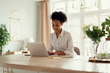 A student surfs looking for information. The woman smiles and prints a message to the client by mail. The influencer works at home online on a computer. The hostess keeps a table on the Internet.