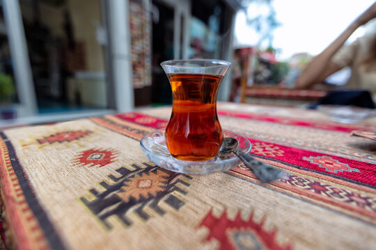 Traditional turkish tea in tulip-shaped glass called ince bellicup on the table of cafe in the historical center of Istanbul. Shallow DOF.