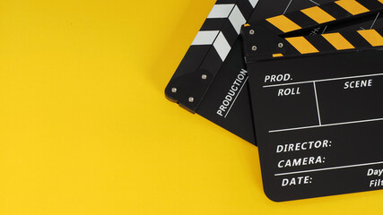 Naklejka premium Two Black and yellow Clapper board or movie slate on yellow background.