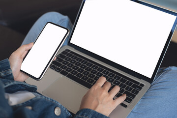 Cell phone and laptop computer mockup, young casual woman in blue jeans sitting on sofa using blank...