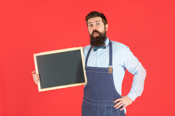 Surprised bearded man hold school blackboard red background copy space, announcement board