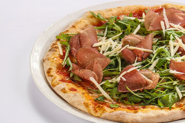 Italian pizza with prosciutto and ruccola