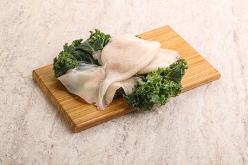 Raw squid over wooden board