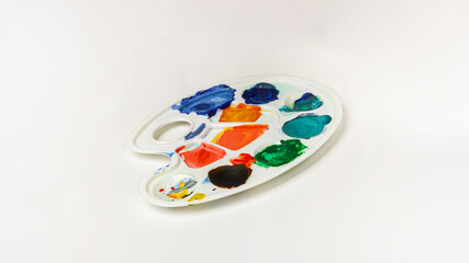 Plastic white palette with paints on a white background