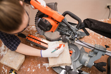 a carpenter Saws furniture parts with a circular saw. Tinted image. to close. circular saw for cutting wood