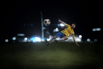 A professional soccer player demonstrates complex moves in the soccer arena wearing a yellow jersey and blue shorts.