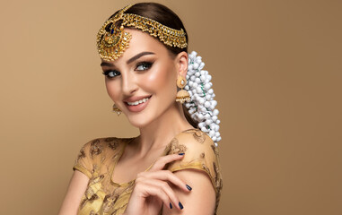 Portrait of beautiful indian girl. Young hindu woman model with golden kundan jewelry set,...