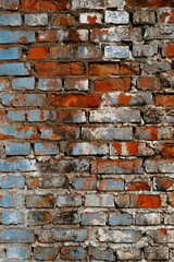 Textured grunge background. Old, ruined red brick wall with faded blue paint elements. Vertical photo
