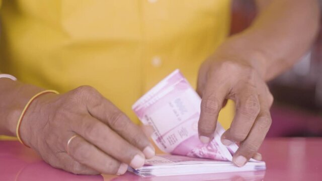 closeup of hands counting money or currency notes on table - concept of tax savings, business profits, finance and banking.