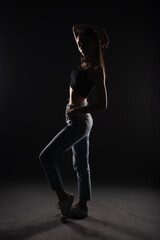 Fototapeta na wymiar Silhouette of girl posing in studio while holding posture