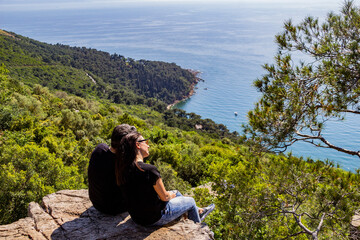Middle eastern couple spending time together on a rock with a view at the sea in buyukada Istanbul, Turkey