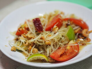 Green papaya salad with tomato chilli and garlic, add shrimps Serve with vegetables on the table, Thai food Taste sour sweet spicy salty