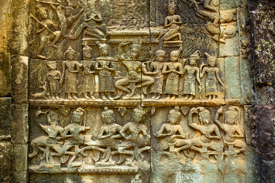 Stone bas-reliefs on the ruins of the ancient city of Angkor Wat in Cambodia. Towers of the temple of the Kmer people streets and ruins of houses. Traveling to the sights of ancient civilizations.