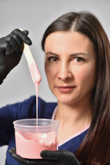 Beautician showing hot wax for waxing depilation