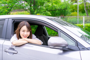 運転席から顔を出す若い女性