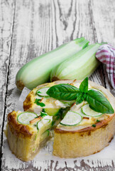 Courgette and feta cheese quiche on white wooden table