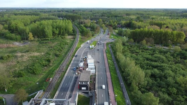 View of end of Temse bridge near nature and forest with traffic driving on the bridge. Cars moving in both directions. Drone aerial bird eye view shot