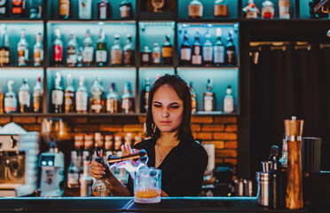 Portrait of young attractive woman bartender Making Cocktail in bar