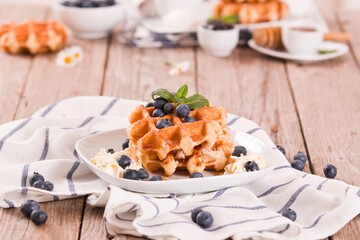Waffles with blueberries and whipped cream.