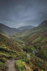 Hikers walk through hills in Lake District