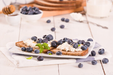 Rye bread with cottage cheese, blueberries and honey.