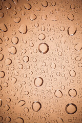 water drops on Brown glass background.
