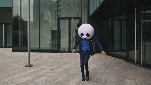 Storytelling video of a businessman wearing a giant panda mask. 