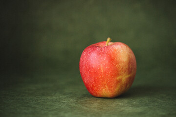 red apple on a green forest watercolor background table
