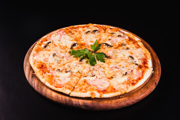 Italian pizza with mushrooms on a wooden board on a black background