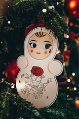 Creative Christmas toy hanging on the Christmas tree with blurry golden festive lights on...