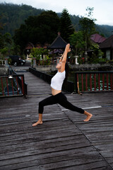 Young woman doing yoga fitness exercise outdoor in beautiful mountains landscape. Morning sunrise