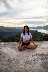 Fototapeta na wymiar Young woman doing yoga fitness exercise outdoor in beautiful mountains landscape. Morning sunrise