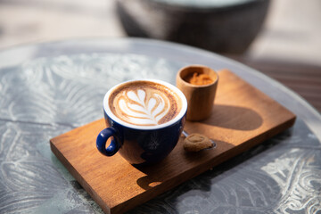 cup of cappuccino with latte art with spoon on the wooden background