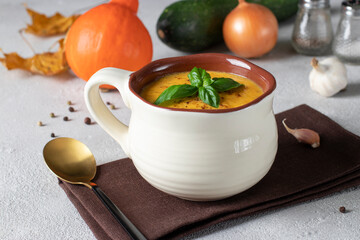 Creamy pumpkin and zucchini soup in a bowl on a light background - Powered by Adobe