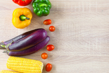 Flat lay of colorful fresh vegetables on wooden table with copy space