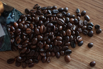 Coffee beans are scattered on a wooden brown table